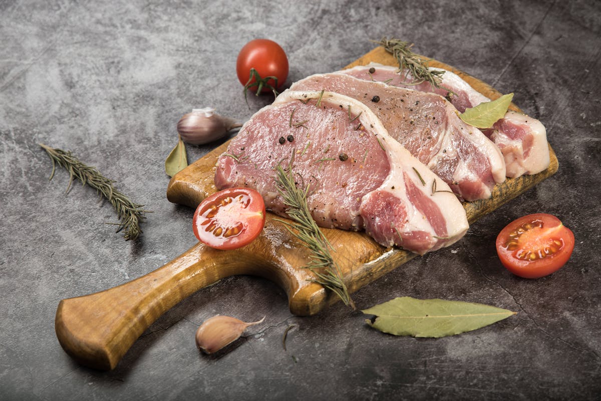 Свински котлети върху дървена дъска